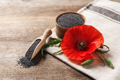 Photo of Composition with poppy seeds and flower on wooden table
