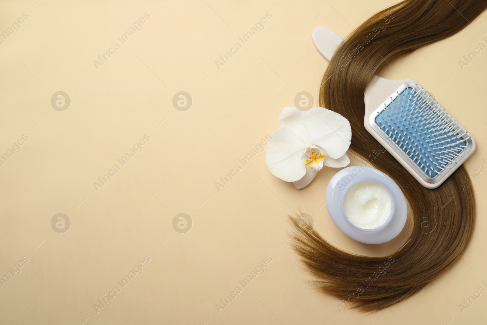 Photo of Jar of cosmetic product, orchid flower, brush and hair lock on beige background, flat lay. Space for text