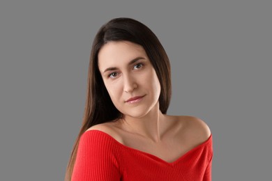 Portrait of beautiful young woman on grey background