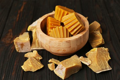 Different natural beeswax blocks on wooden table
