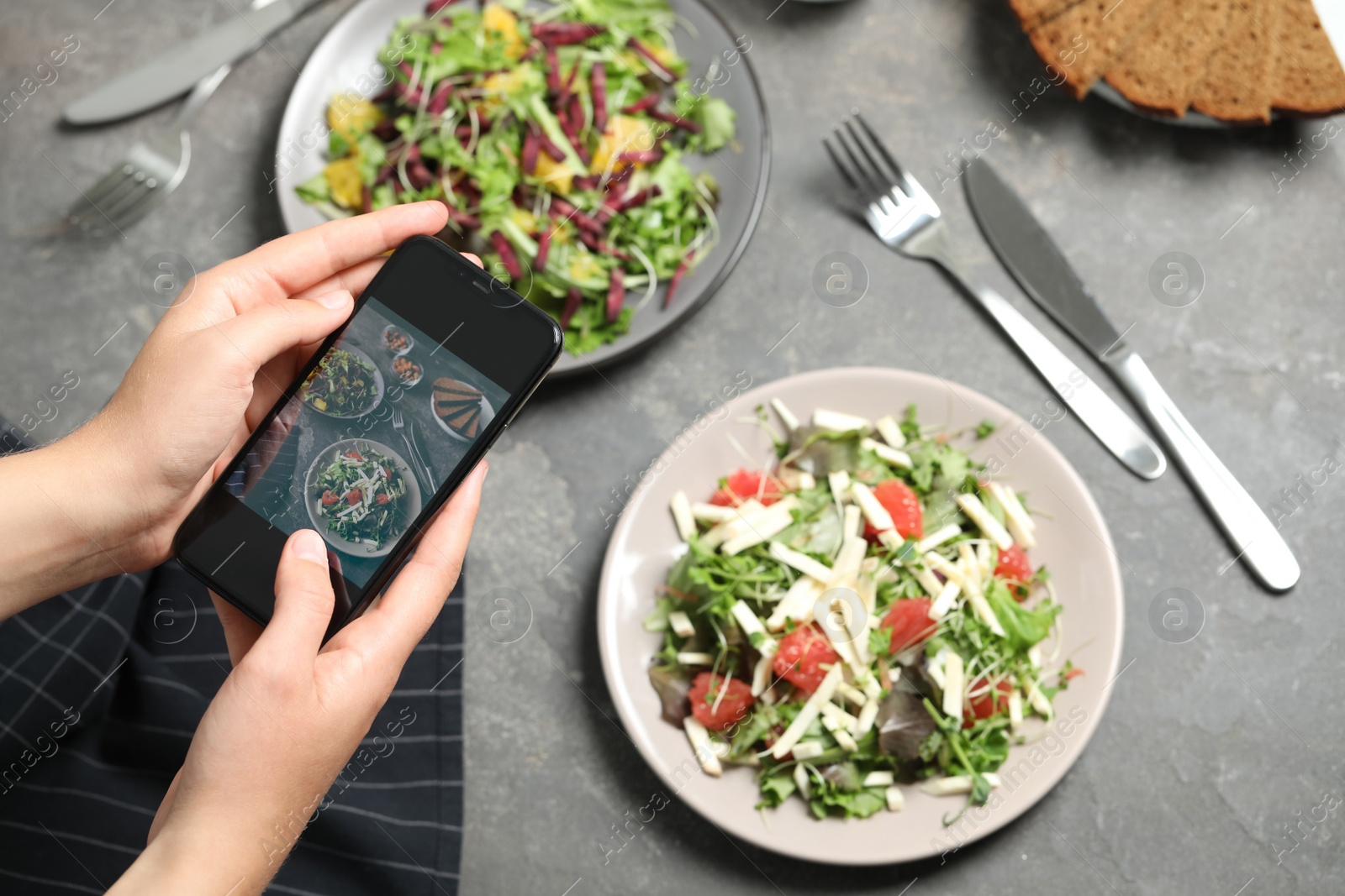 Photo of Blogger taking picture of salads at table, top view