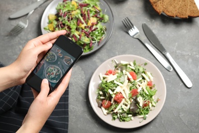 Blogger taking picture of salads at table, top view