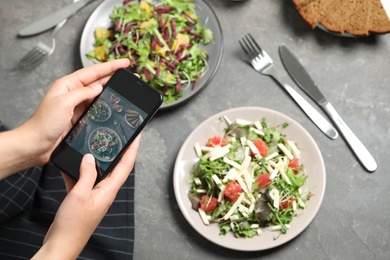 Photo of Blogger taking picture of salads at table, top view