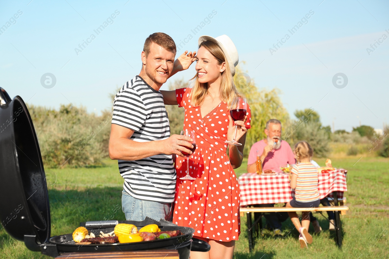 Photo of Happy family having barbecue in park on sunny day