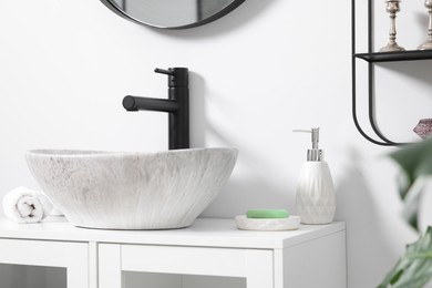 Photo of Different bath accessories and personal care products near sink on bathroom vanity