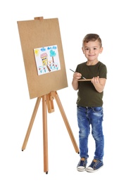 Child painting picture on easel against white background