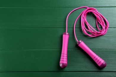 Photo of Skipping rope on green wooden table, top view. Space for text