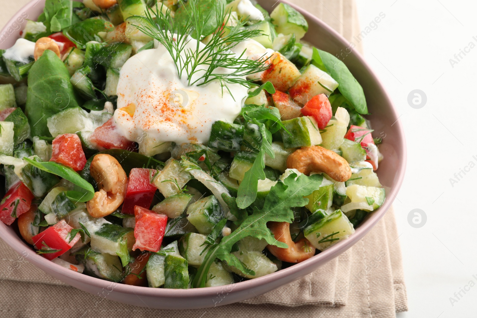 Photo of Bowl of delicious cucumber salad on white table, closeup