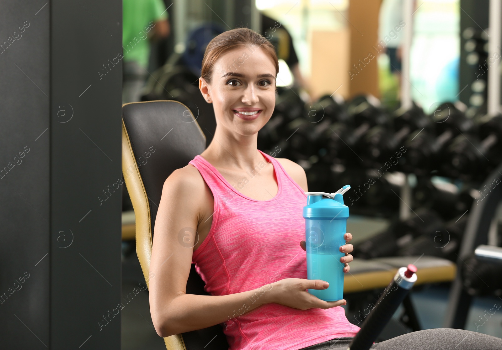 Photo of Athletic young woman with protein shake in gym