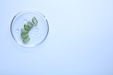 Photo of Cut aloe vera and drops of cosmetic gel on light blue background, top view. Space for text