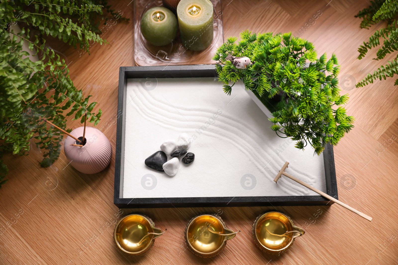 Photo of Beautiful miniature zen garden, candles and oil lamps on table, above view