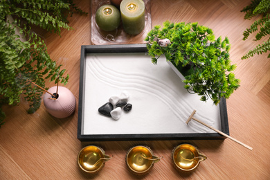 Photo of Beautiful miniature zen garden, candles and oil lamps on table, above view