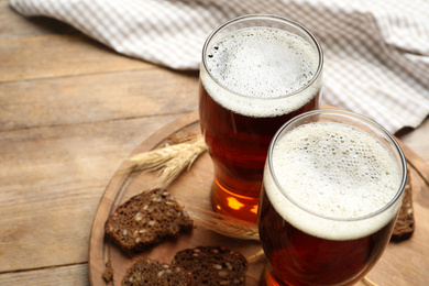 Delicious kvass, bread and spikes on wooden table. Space for text