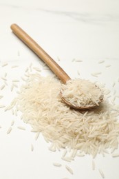 Photo of Raw basmati rice with spoon on white table