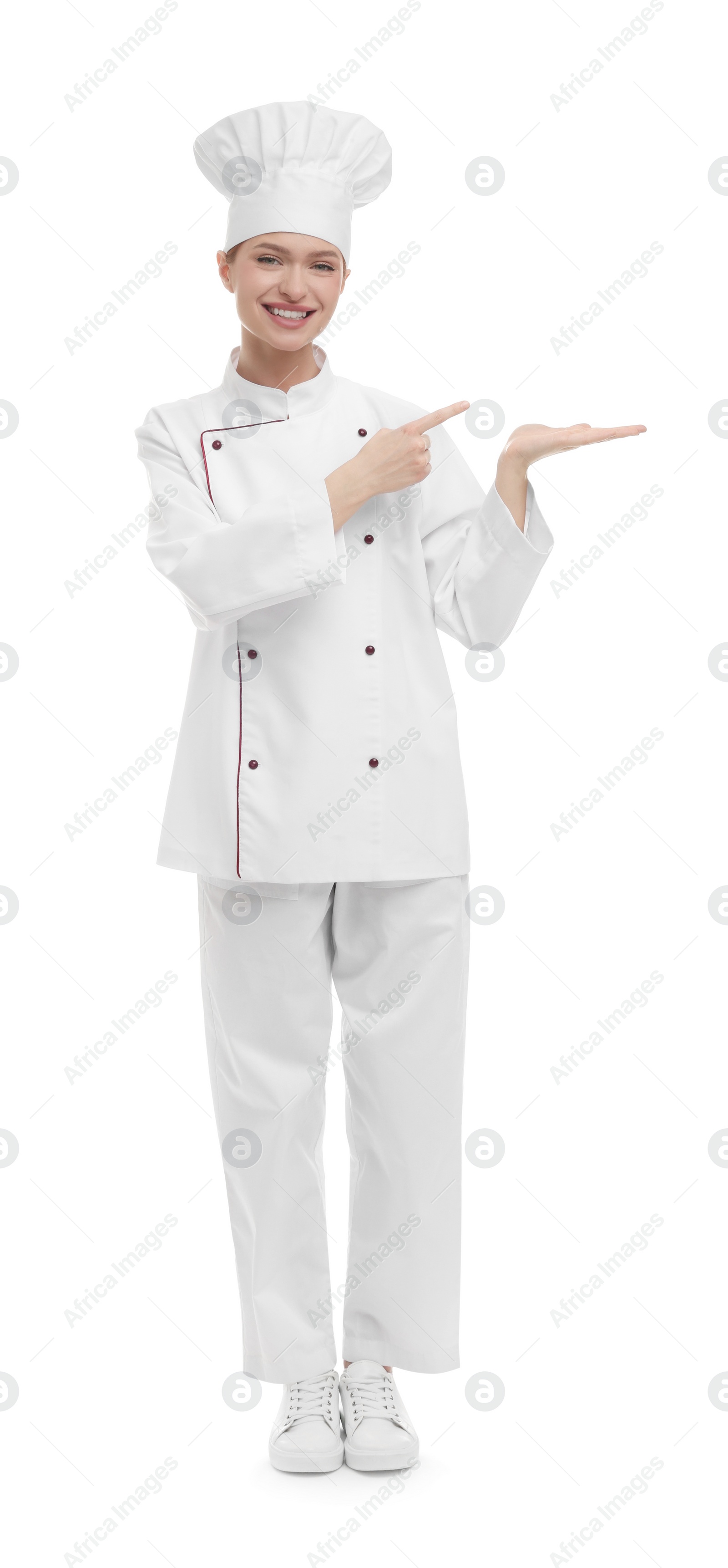 Photo of Happy woman chef in uniform pointing at something on white background