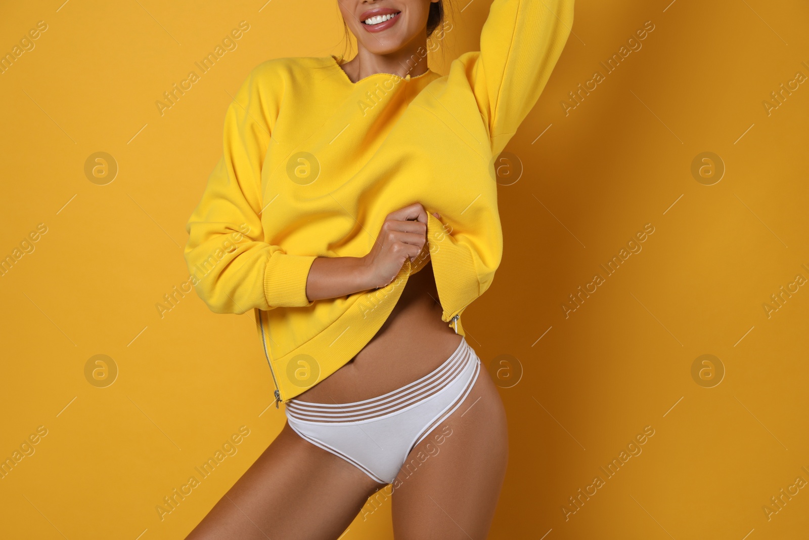 Photo of Woman in white panties on yellow background, closeup