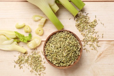 Photo of Fennel seeds and fresh stalks on wooden table, flat lay