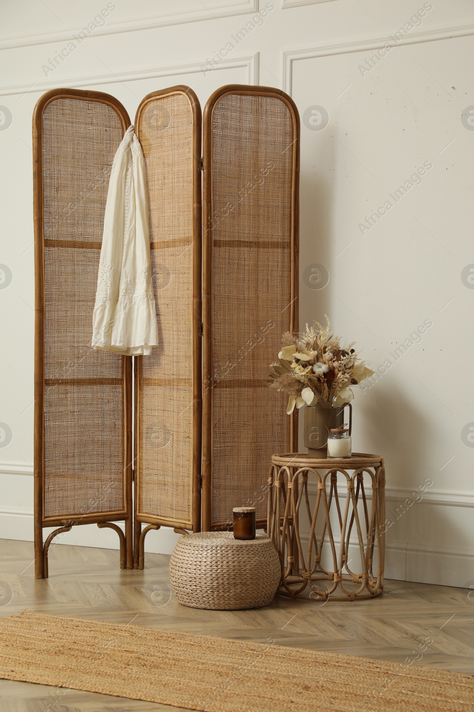 Photo of Folding screen and small table with flowers in room. Interior design