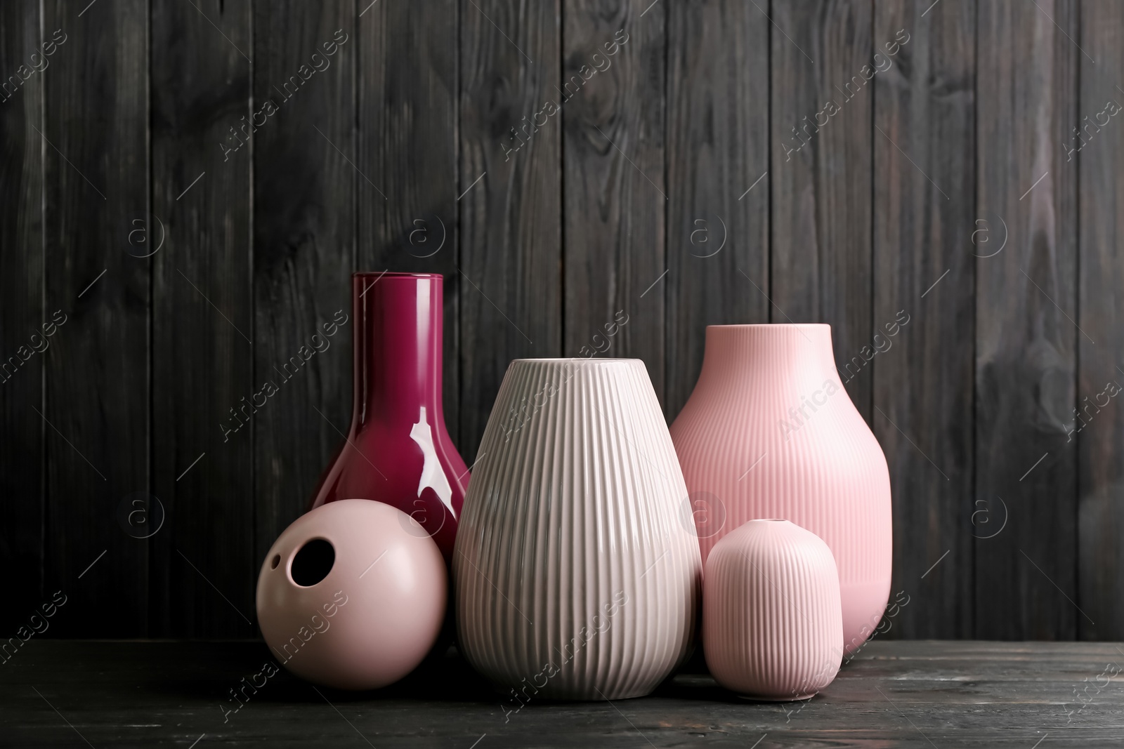 Photo of Stylish ceramic vases on black wooden table