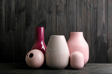 Photo of Stylish ceramic vases on black wooden table