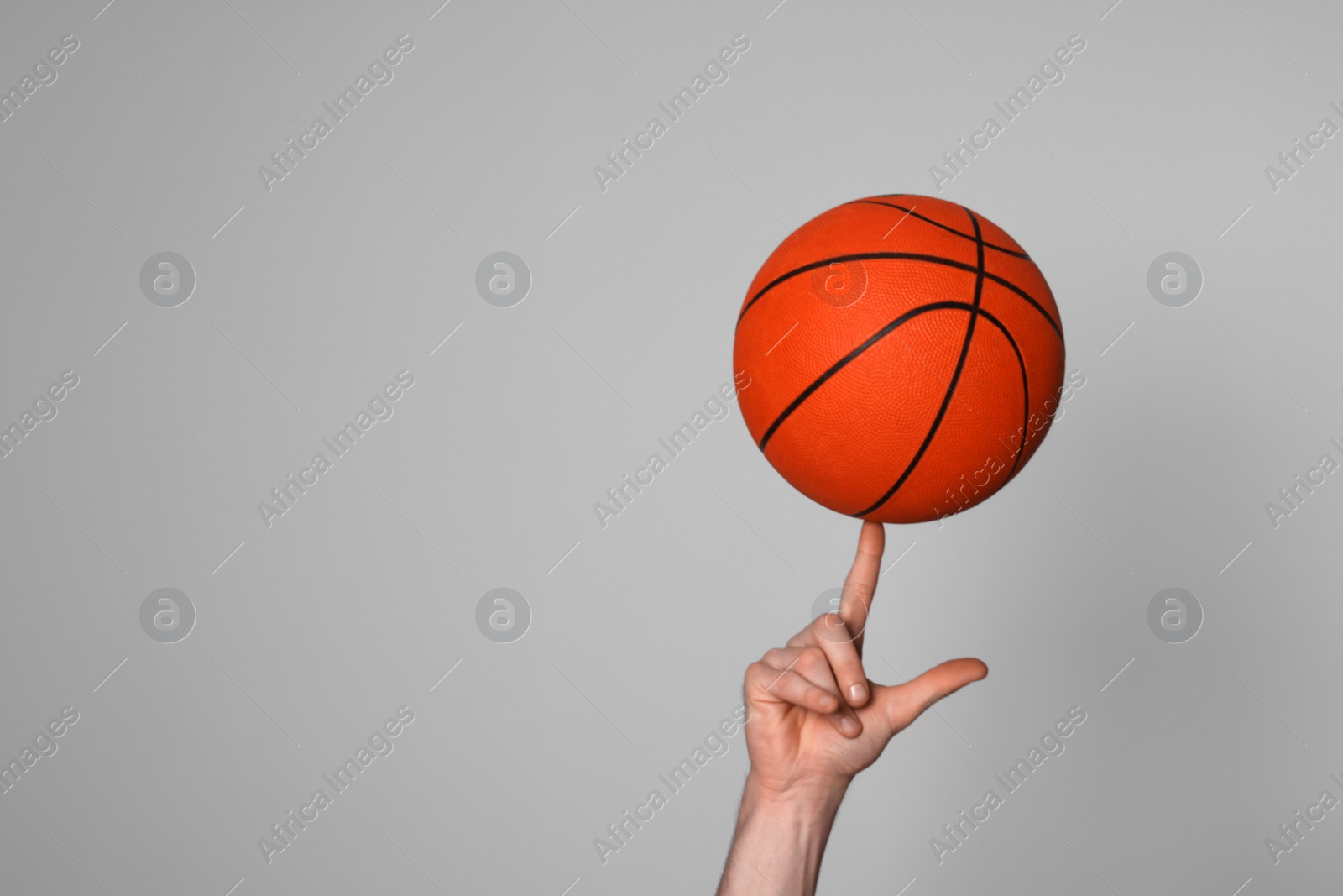 Photo of Man with basketball ball on light grey background, closeup. Space for text
