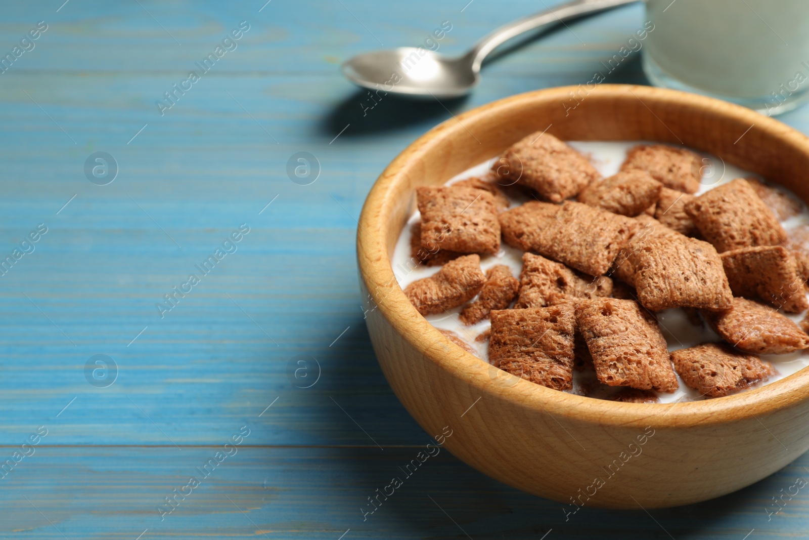 Photo of Tasty corn pads with milk served on turquoise wooden table, closeup. Space for text