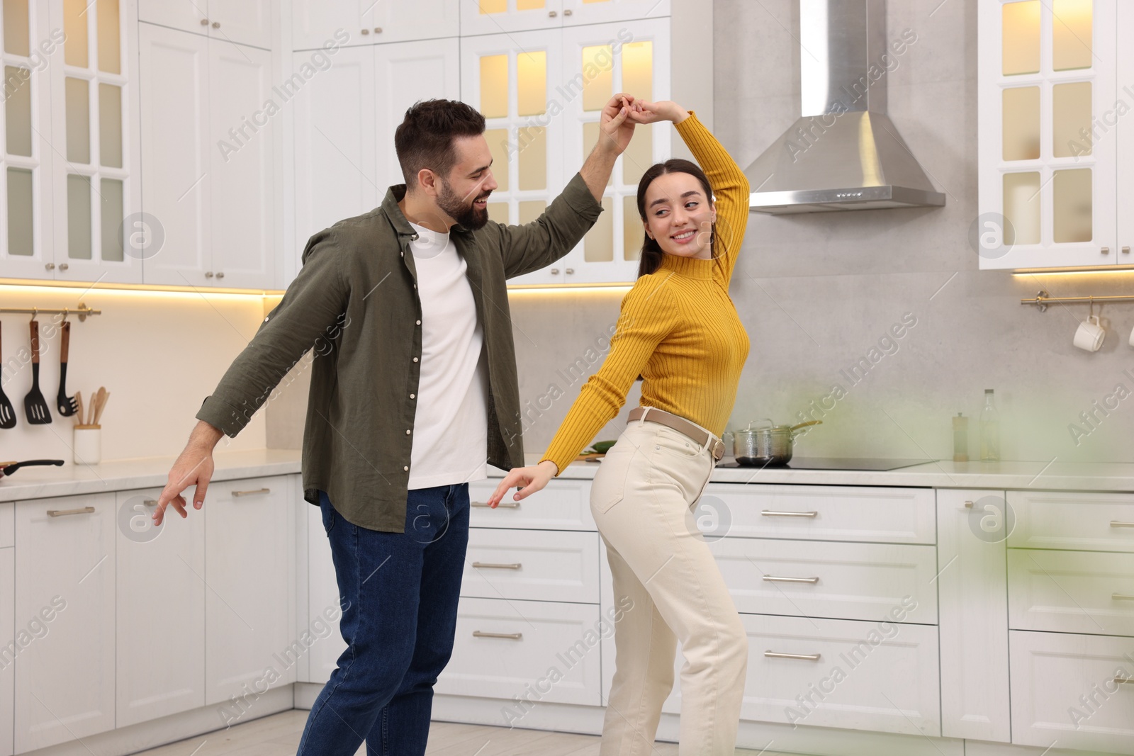 Photo of Happy lovely couple dancing together in kitchen