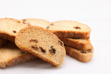 Photo of Sweet hard chuck crackers with raisins on white wooden table, closeup