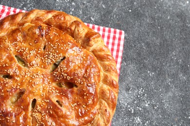 Photo of Tasty homemade pie on grey table, top view. Space for text