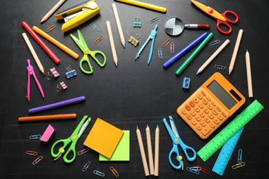 Photo of Flat lay composition with scissors and school supplies on dark background. Space for text
