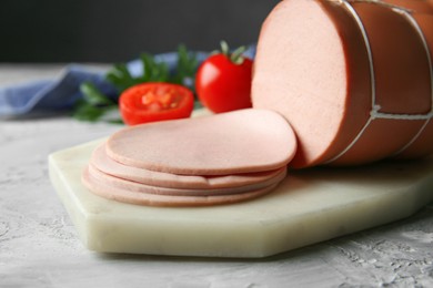 Photo of Delicious boiled sausage on grey textured table, closeup