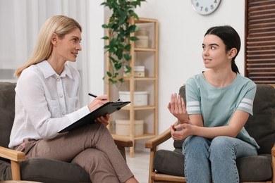 Psychologist working with teenage girl in office