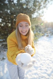 Photo of Woman with snowball outdoors, focus on hand