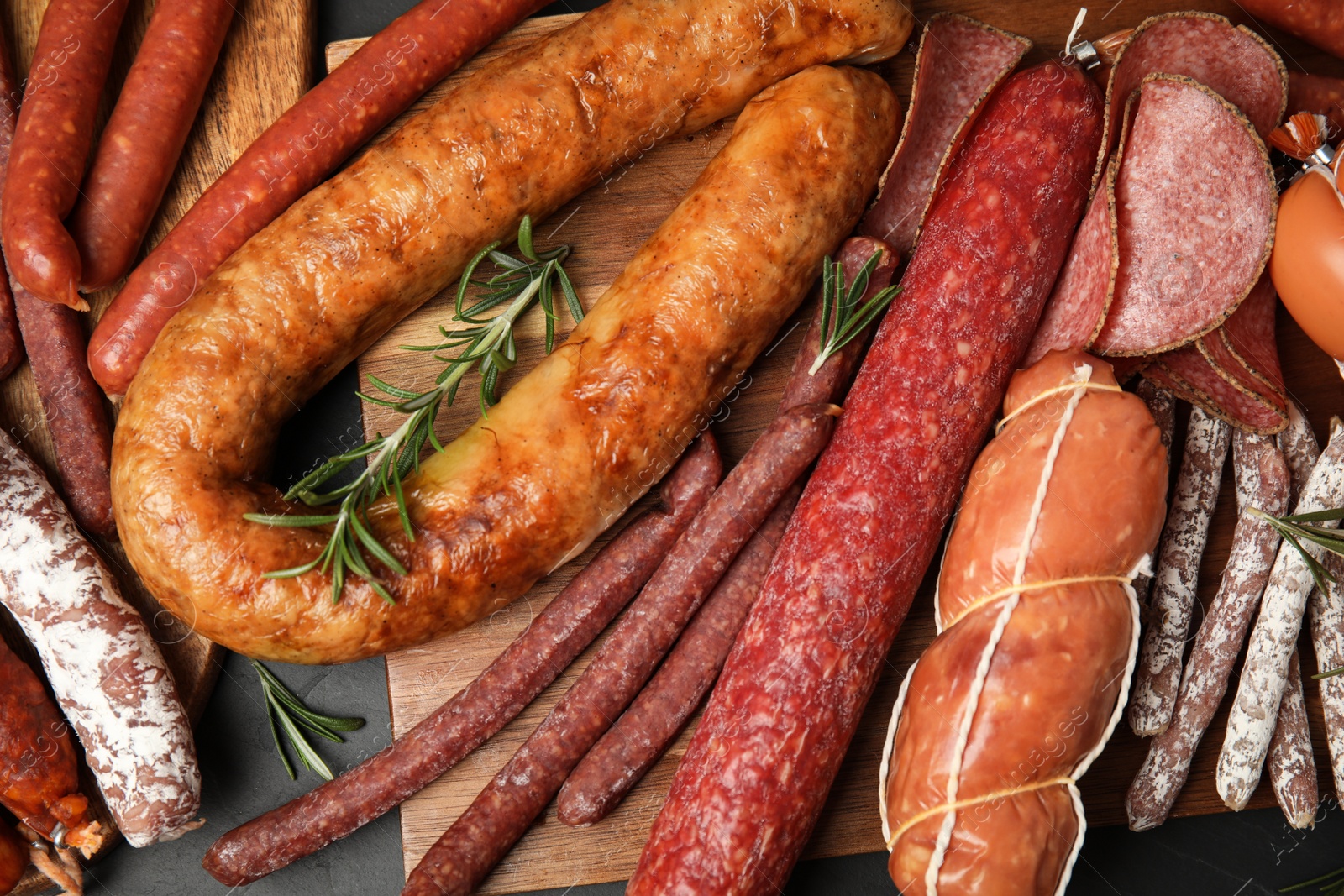 Photo of Different tasty sausages on black table, flat lay