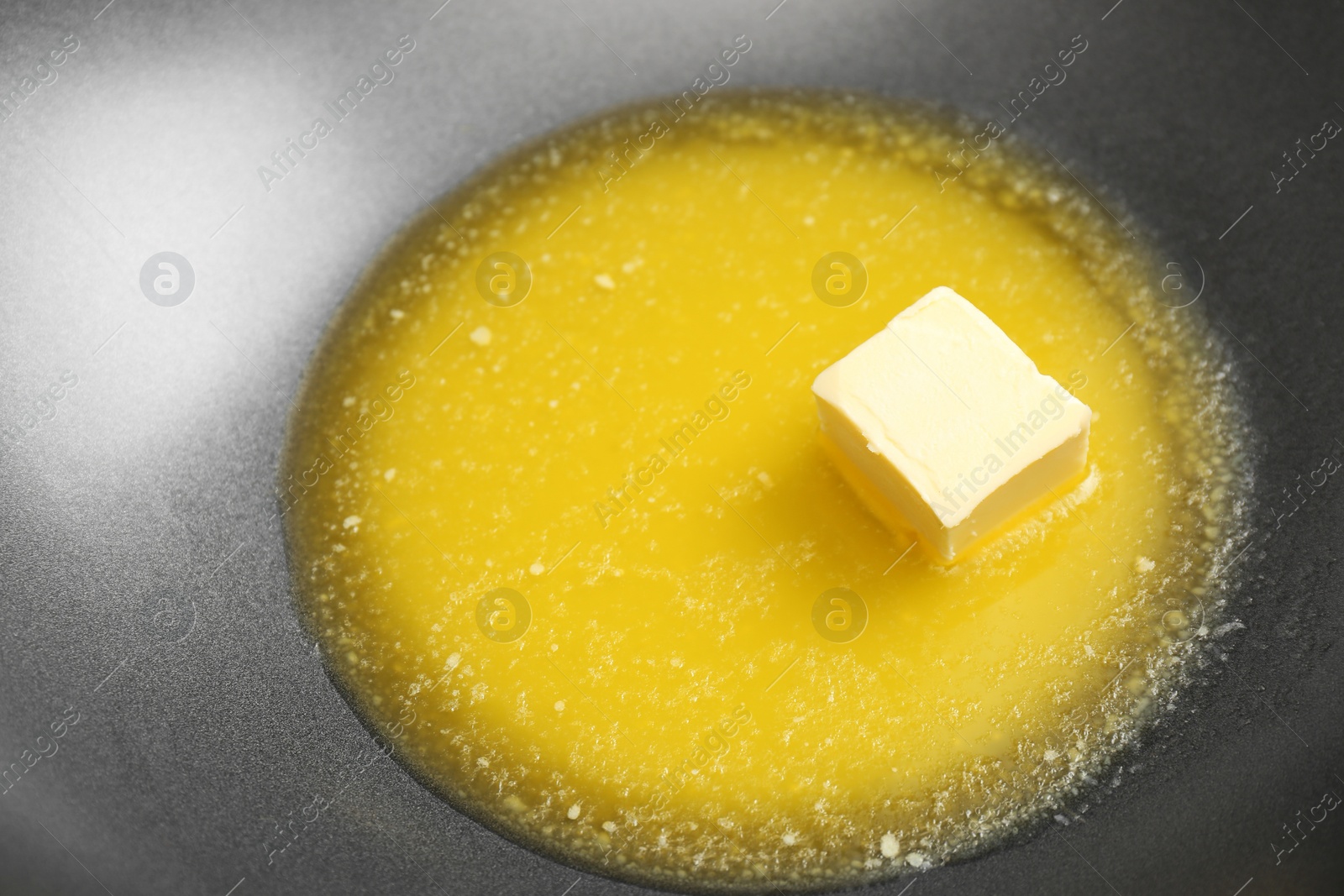 Photo of Wok pan with melted butter, closeup view