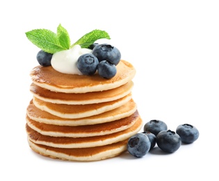 Tasty pancakes with blueberries, sauce and mint on white background