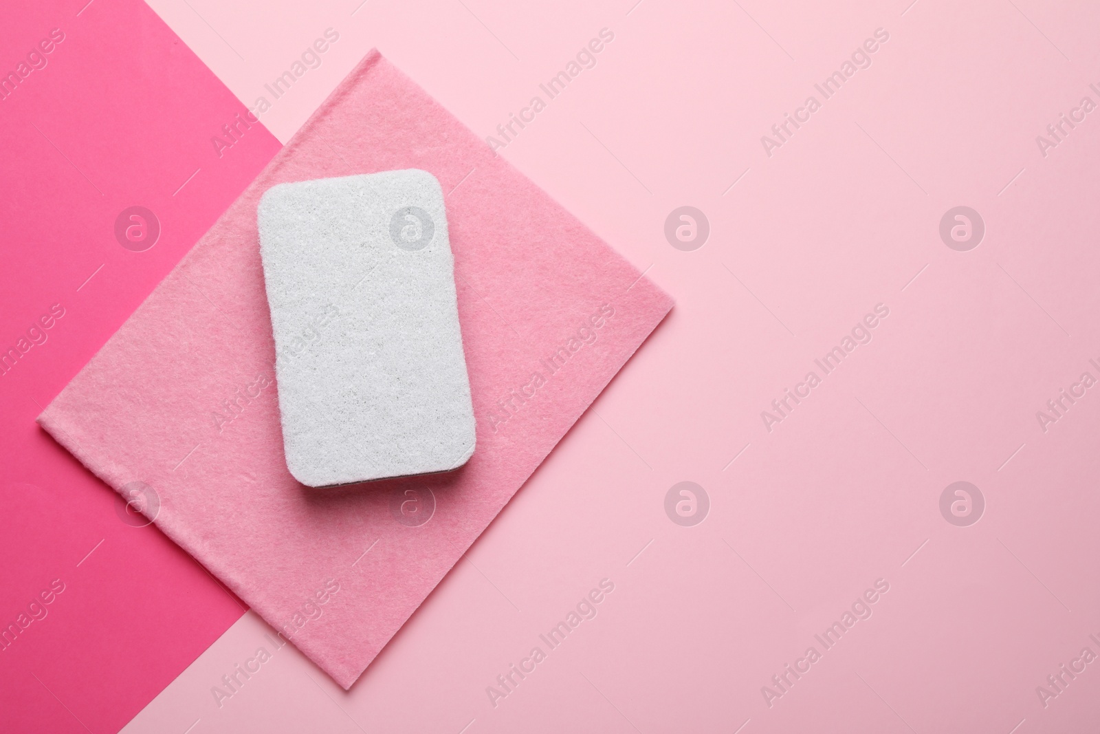 Photo of Sponge and rag on pink background, top view. Space for text