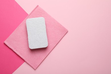 Photo of Sponge and rag on pink background, top view. Space for text