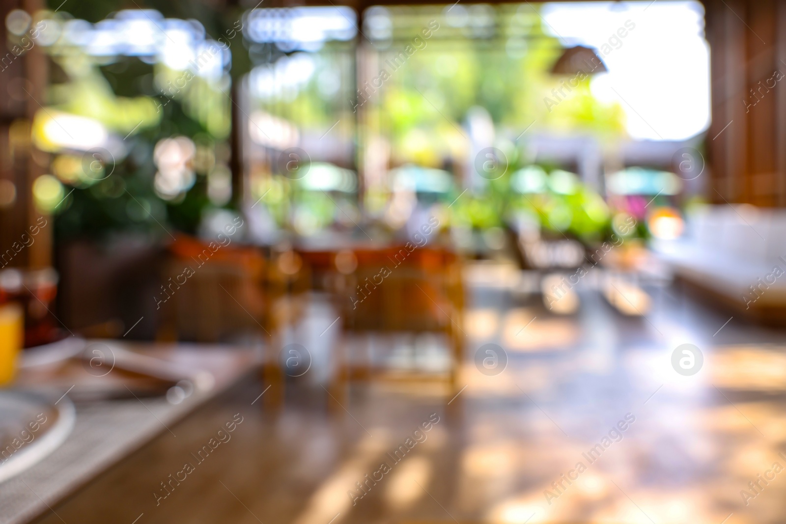 Photo of Blurred view of comfortable cafeteria with furniture