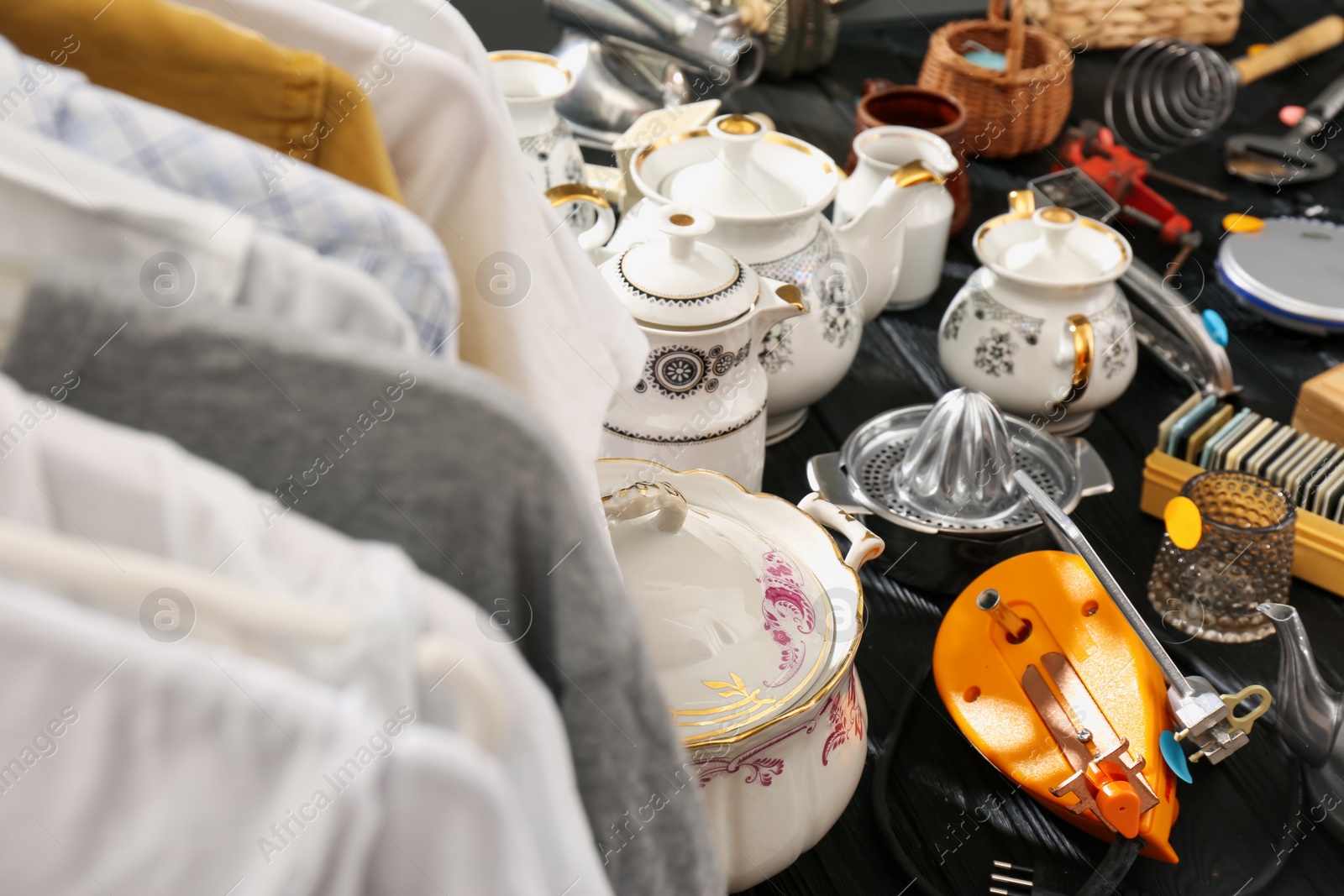 Photo of Many different stuff on black wooden table. Garage sale