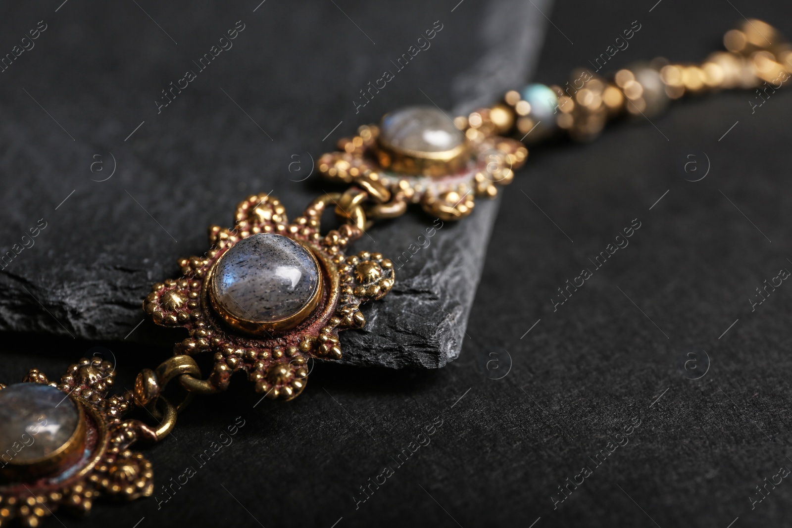 Photo of Elegant bracelet on black background, closeup. Luxury jewelry