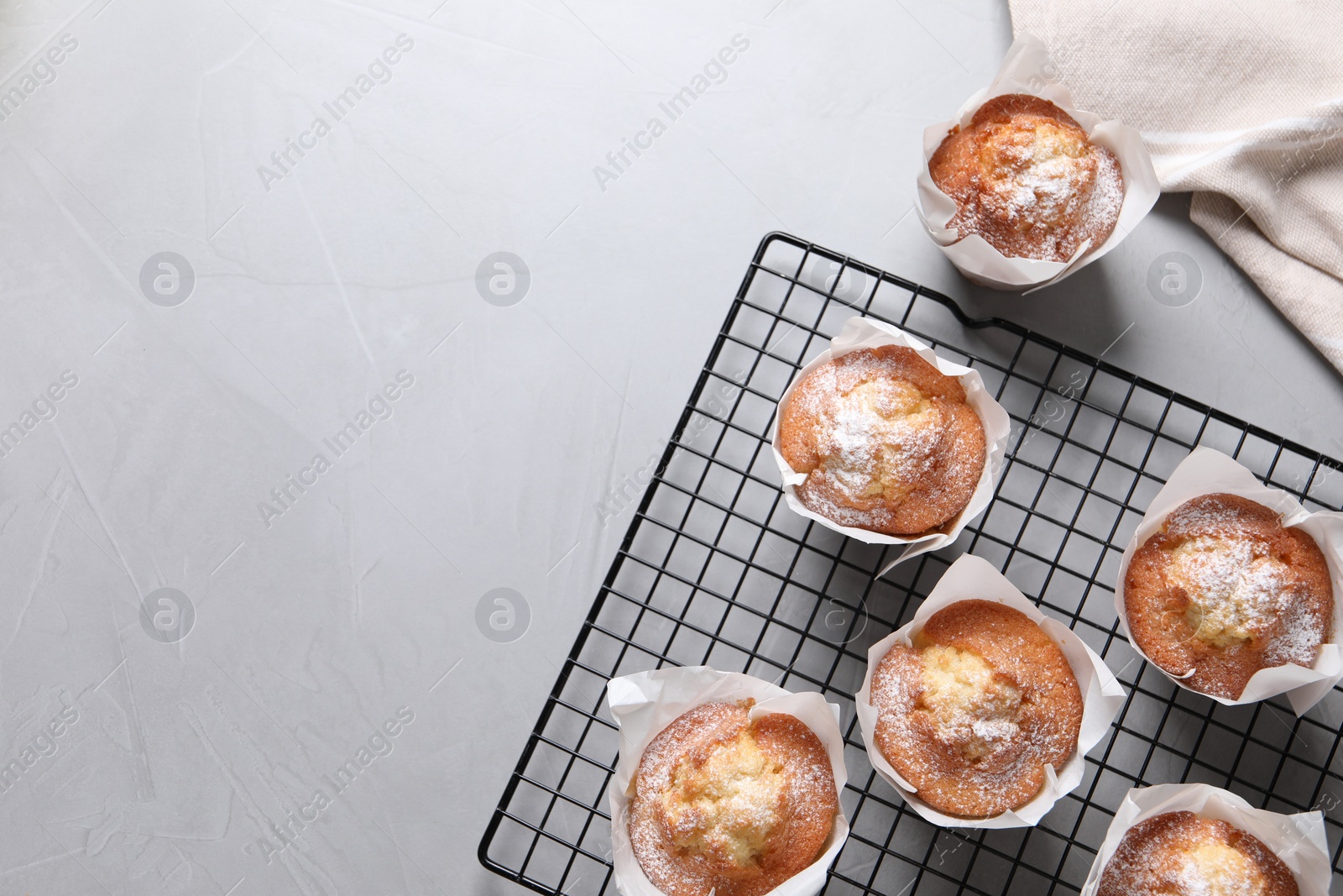 Photo of Delicious muffins on grey table, flat lay. Space for text