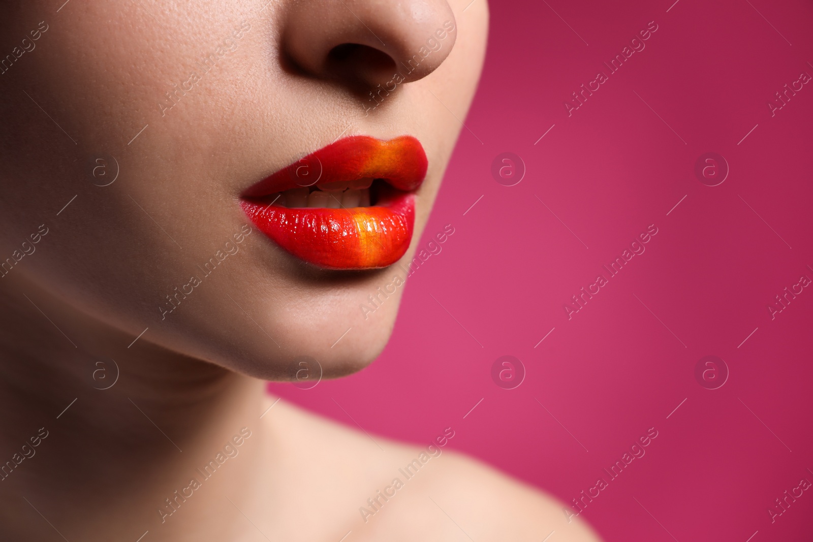 Photo of Young woman with beautiful lips makeup on pink background, closeup. Space for text