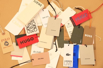 Leiden, Netherlands - December 6, 2023: Different clothing tags on kraft paper sheet, flat lay