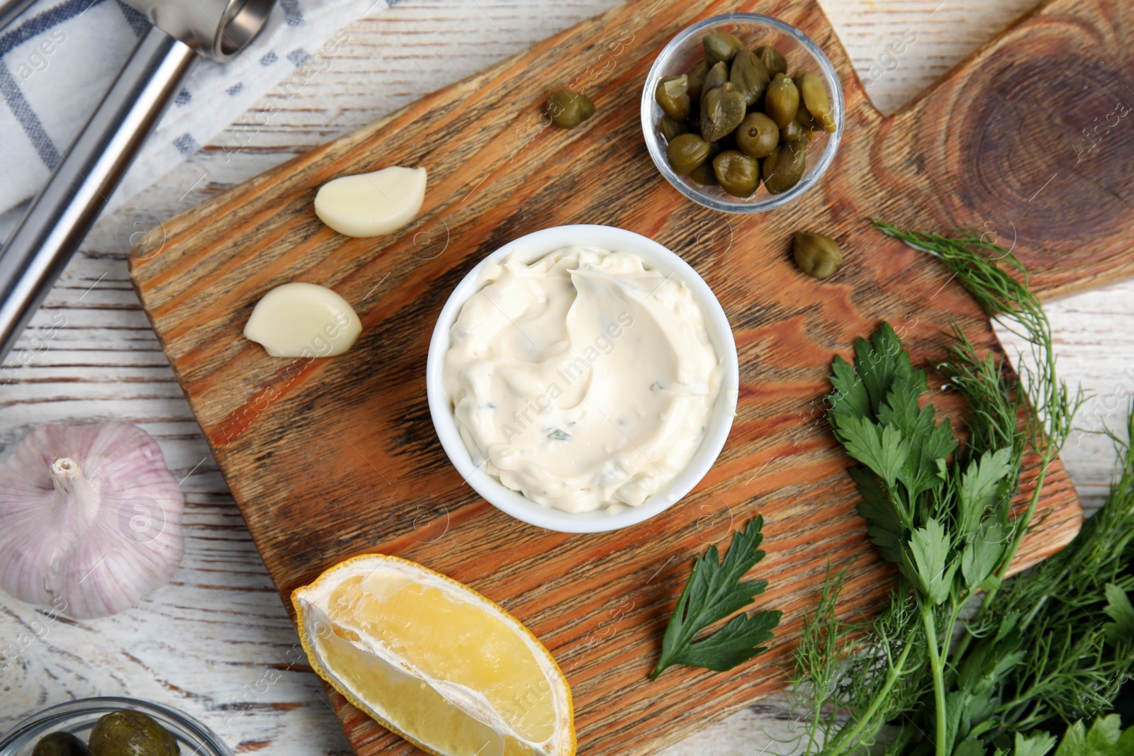 Photo of Tasty tartar sauce and ingredients on wooden table, flat lay