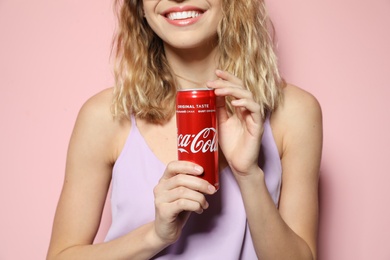 MYKOLAIV, UKRAINE - NOVEMBER 28, 2018: Young woman with Coca-Cola can on color background, closeup