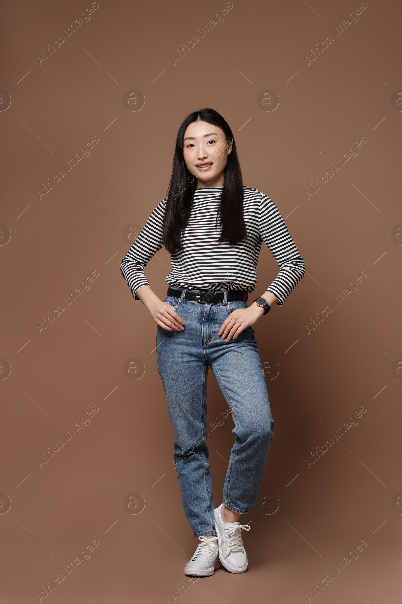 Photo of Full length portrait of smiling woman on brown background