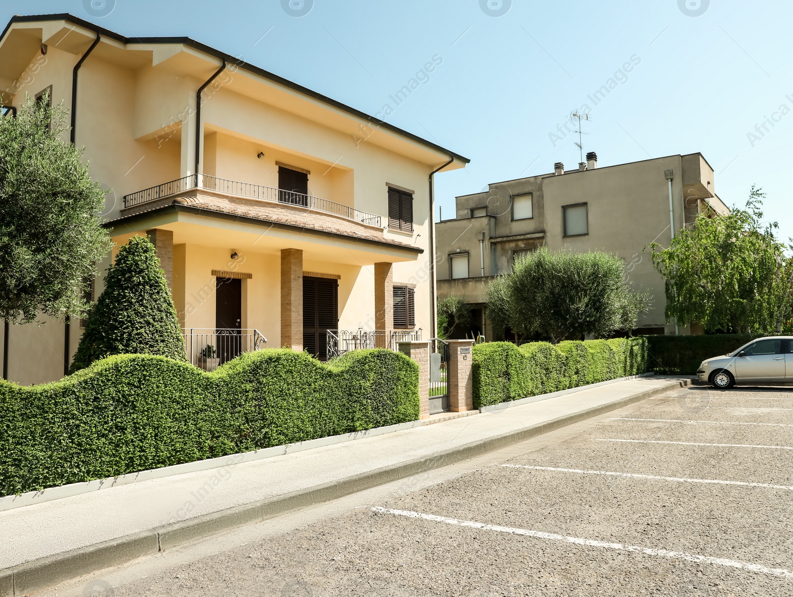 Photo of Residential building with beautiful green hedge on sunny day