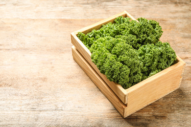 Fresh kale leaves on wooden table. Space for text