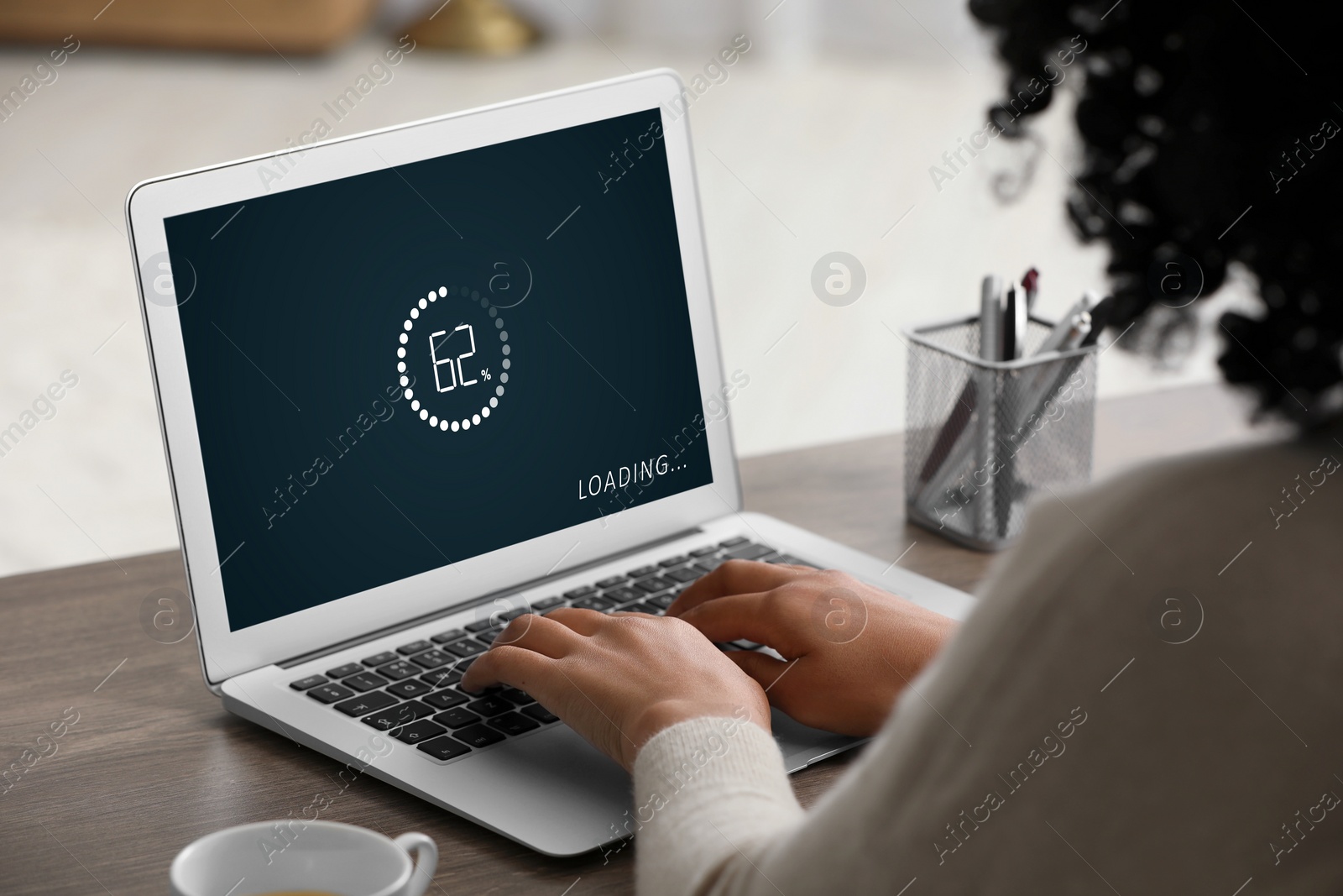 Image of Loading screen displaying progress. Woman working on laptop at table indoors, closeup